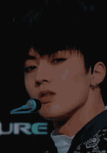 a close up of a person 's face with a microphone in their hand .