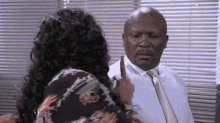 a woman is pointing at a man in a tie