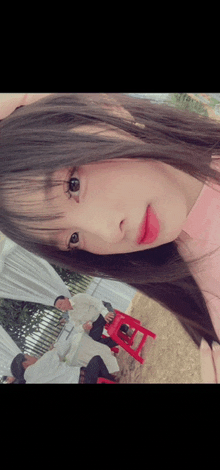 a girl is taking a picture of herself with a red stool in the background