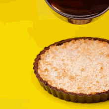 chocolate is being poured over a coconut pie
