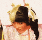 a close up of a woman 's face with a bow in her hair .