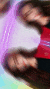a blurry picture of a person 's face with a purple shirt on