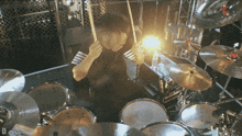 a man playing a drum set with the letter d on the bottom