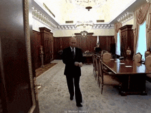 a man in a suit and tie is walking through a large room with the words markus ' world on the bottom