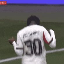 a soccer player wearing a white jersey with the number 30 on it