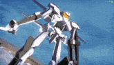 a white robot with orange eyes is flying in the air .