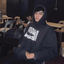 a man wearing a sierra camp hoodie sits at a table