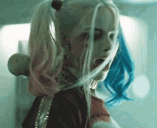 harley quinn from suicide squad is holding a bat with her mouth open