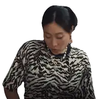 a woman wearing a zebra print shirt and pearl necklace