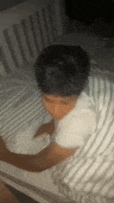 a person laying on a bed with a striped comforter