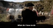 a man in a pirate hat is standing in a field talking to someone .