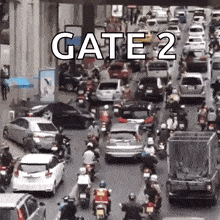 a lot of cars and motorcycles are driving down a street with the words gate 2 on the bottom .