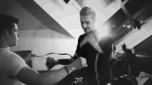a couple of men are standing next to each other in a room .