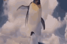 a cartoon penguin is flying through the clouds in the sky .