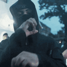 a man wearing a black hooded jacket and a ny hat