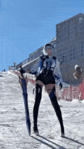 a woman in a costume is holding a sword in the snow .