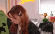 a girl with red hair is sitting in front of a green chair that says croft lab