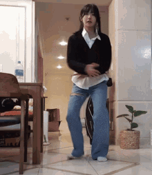 a woman is dancing in a room with a bottle of aquafina water
