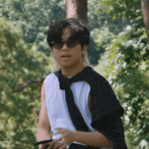 a man wearing sunglasses and a black scarf around his shoulder