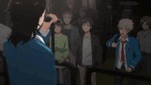 a group of people are standing in a dark room with a man holding a microphone in front of them