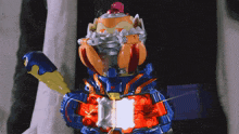 a toy robot with a blue arm and a red head