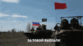 a group of soldiers on a tank with russian flags behind them and the words " за тобой выехали " on the bottom
