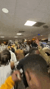 a crowd of people are gathered in a room with a sign that says ' a ' on it .