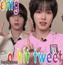 two young men are giving a peace sign and one of them is wearing a pink shirt and tie .