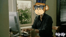 a man with a monkey on his head is typing on a computer with gif jif written below him