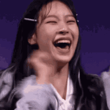 a close up of a woman laughing with her mouth open and her eyes closed .