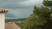 a roof with a tile roof and a cloudy sky behind it
