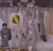 a group of people are dancing in a room with balloons in the background .