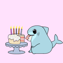a shark is sitting next to a birthday cake with candles on it