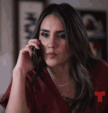a woman talking on a cell phone with a red t on the bottom right