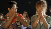 a man and a woman are clapping their hands in a crowd .
