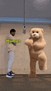 a man standing next to a teddy bear with the word human above him