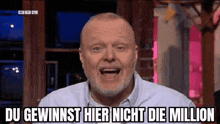 a man with a beard is making a funny face and saying du gewinnst hier nicht die million .
