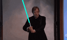a man in a suit is holding a light saber