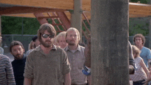 a man is pointing a gun at someone while another man looks on
