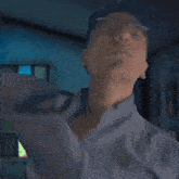 a pixelated image of a man with glasses adjusting his shirt