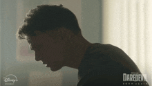 a poster for daredevil born again shows a man in a dark room