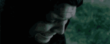 a close up of a man 's face in the dark with a tear running down his face .