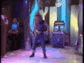 a woman is dancing in a room with a purple light
