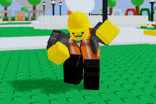 a lego character wearing a hard hat and safety vest is standing in a park .