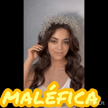 a woman wearing a tiara with the word malefica in yellow letters