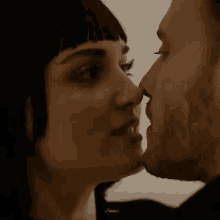 a man and a woman are kissing each other .