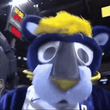 a mascot wearing a blue and white outfit with the letter g on his chest