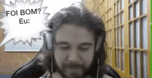 a man with long hair and a beard is wearing headphones and talking to someone .