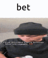 a man wearing a black hat and a black shirt with the word bet on the bottom .
