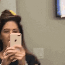 a woman is taking a picture of herself with her cell phone